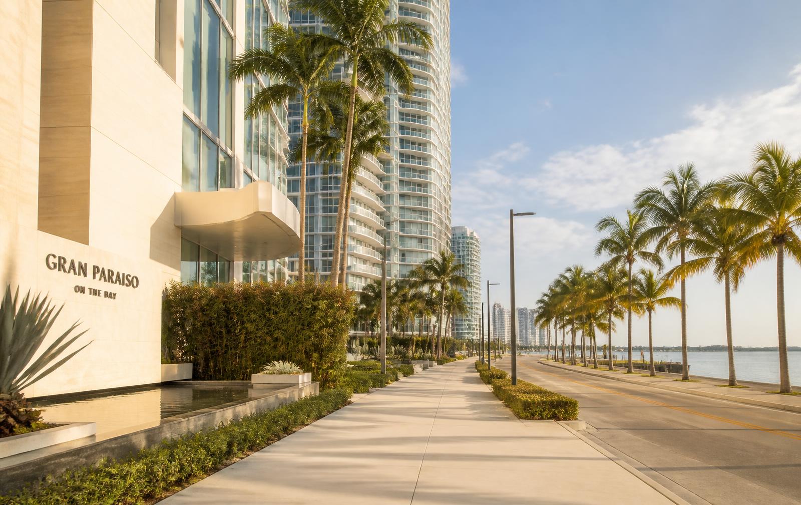 Bright Edgewater Miami street with palm trees, modern towers and a glimpse of Biscayne Bay